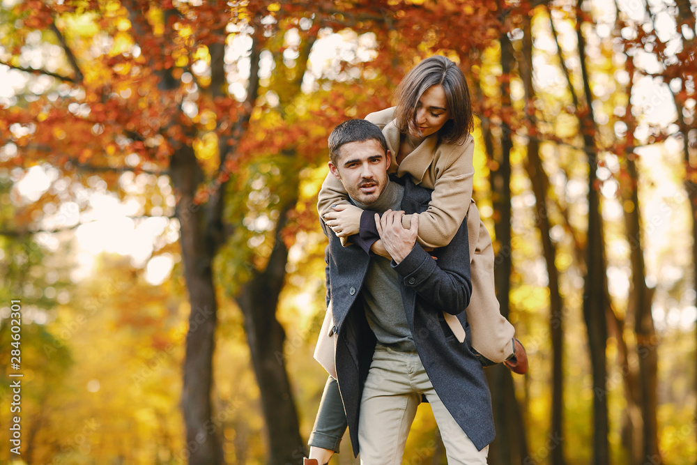lovely couple walking around the park during autumn lovely couple walking around the park during autumn