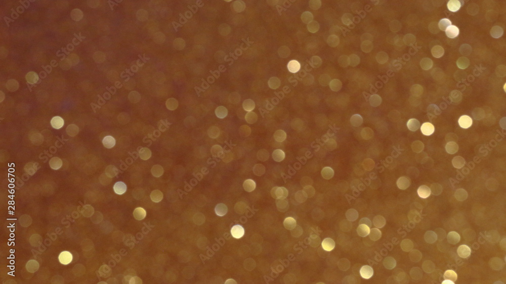 Golden glittering background, bokeh effect using defocused mode. With copy space for insert text Golden glittering background, bokeh effect using defocused mode. With copy space for insert text