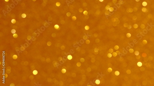 Golden glittering background, bokeh effect using defocused mode. With copy space for insert text