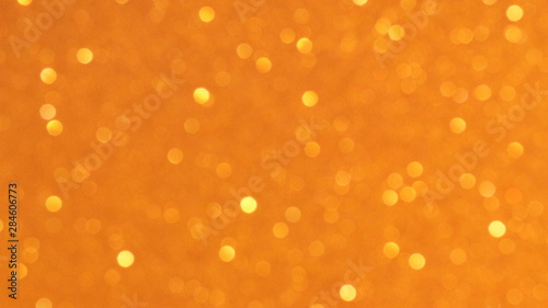 Golden glittering background, bokeh effect using defocused mode. With copy space for insert text