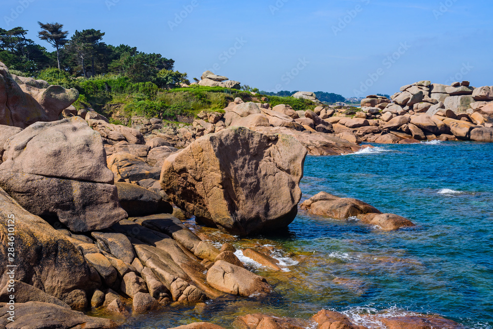 Fototapeta premium Seascape with huge pink granite boulders near Plumanach. The coast of pink granite is a unique place in Brittany. France