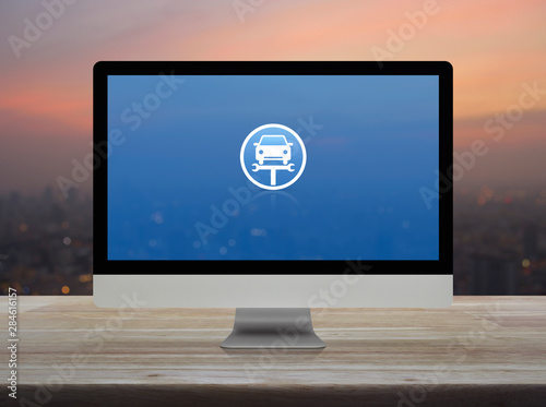 Service fix car with wrench tool flat icon on desktop modern computer monitor screen on wooden table over blur of cityscape on warm light sundown  Business repair car service online concept