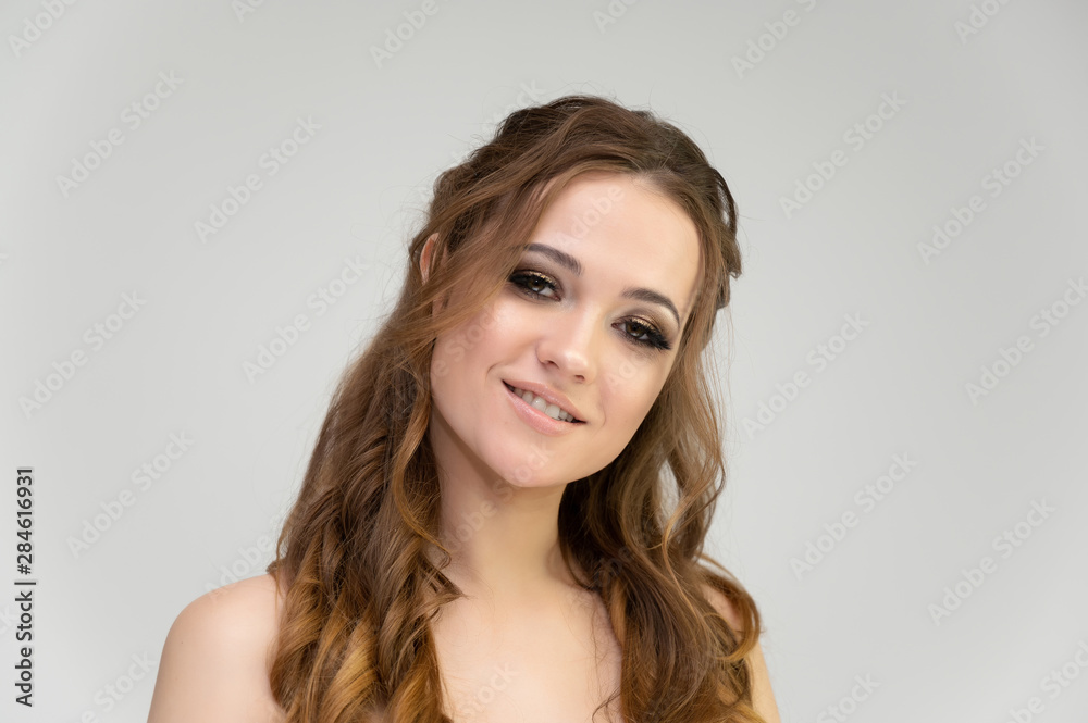 Close-up photo portrait of a pretty brunette woman girl with long beautiful curly hair on a white background. Standing in front of the camera Close-up photo portrait of a pretty brunette woman girl with long beautiful curly hair on a white background. Standing in front of the camera