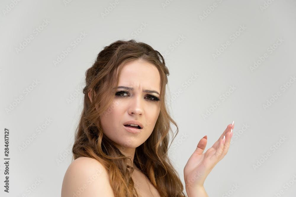 Close-up photo portrait of a pretty brunette woman girl with long beautiful curly hair on a white background. Standing in front of the camera Close-up photo portrait of a pretty brunette woman girl with long beautiful curly hair on a white background. Standing in front of the camera