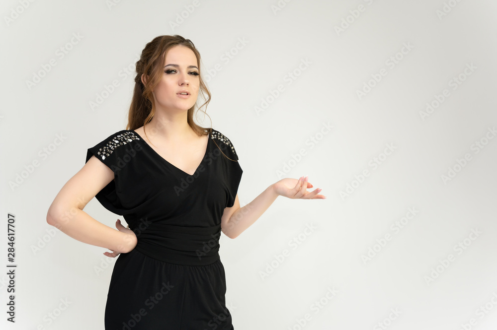 Photo waist-length portrait of a pretty brunette woman girl with long beautiful curly hair on a white background in a black dress. Talking in different poses. Standing facing the camera. Photo waist-length portrait of a pretty brunette woman girl with long beautiful curly hair on a white background in a black dress. Talking in different poses. Standing facing the camera.