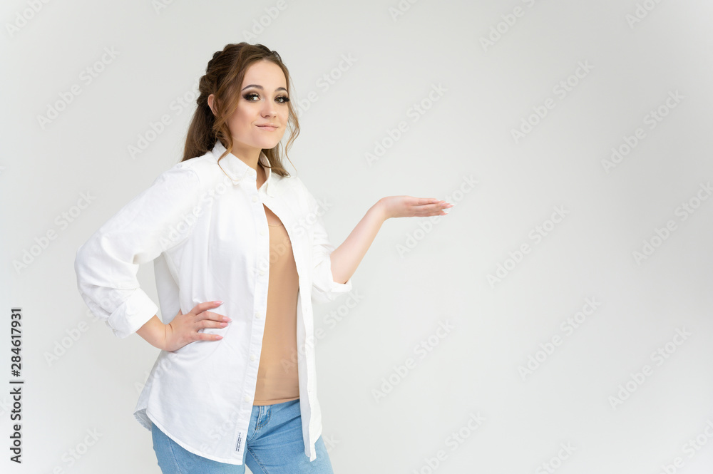 Photo waist-length portrait of a pretty brunette woman girl with long beautiful curly hair on a white background in a white shirt. Talking in different poses. Standing facing the camera. Photo waist-length portrait of a pretty brunette woman girl with long beautiful curly hair on a white background in a white shirt. Talking in different poses. Standing facing the camera.
