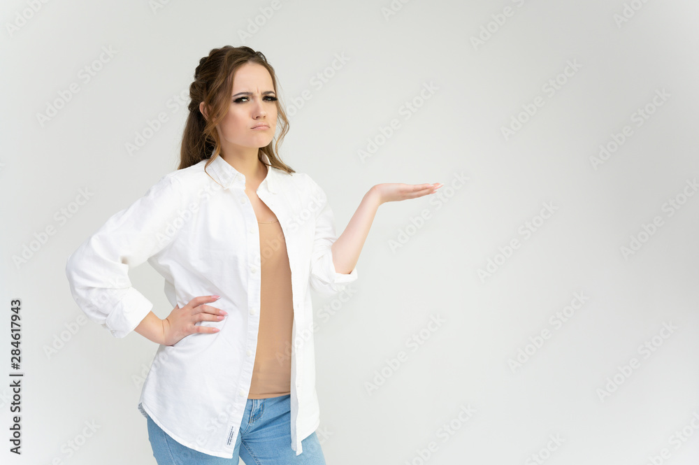 Photo waist-length portrait of a pretty brunette woman girl with long beautiful curly hair on a white background in a white shirt. Talking in different poses. Standing facing the camera. Photo waist-length portrait of a pretty brunette woman girl with long beautiful curly hair on a white background in a white shirt. Talking in different poses. Standing facing the camera.