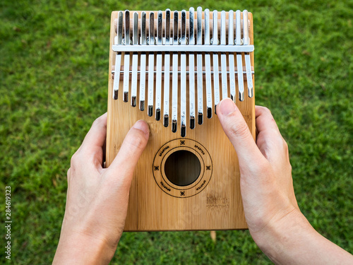 Holding kalimba in hands and playing