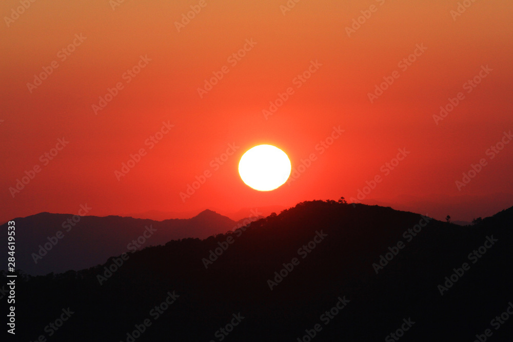 Sunset in sky and cloud, beautiful colorful twilight time with silhouette of mountain.