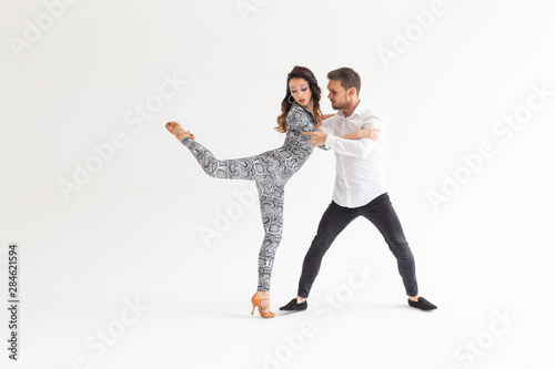 Young love couple dancing social danse kizomba or bachata over white background with copy space