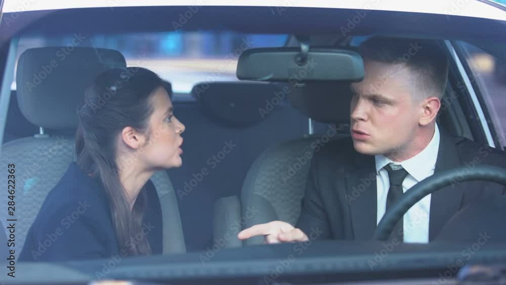 Couple desperately quarreling in car, man kissing lady, hot-tempered relations