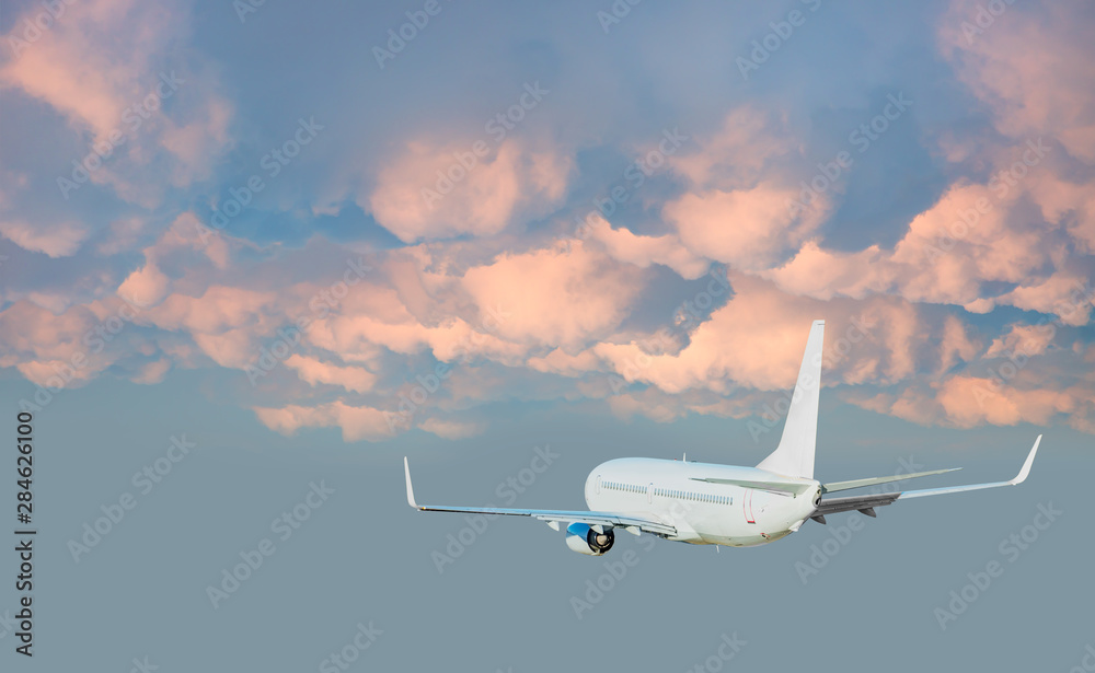 Obraz premium Samolot lecący nad tropikalnym morzem o zachodzie słońca