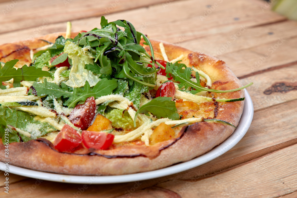 pizza with fresh vegetables on the wooden background