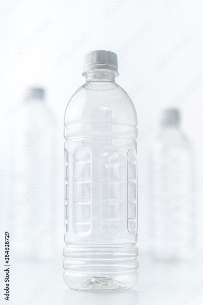 Plastic bottles in various shapes and sizes on white table and background Plastic bottles in various shapes and sizes on white table and background