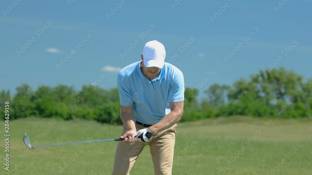 Male golfer hitting shot with driver on green, rejoicing in good shot, slow-mo Male golfer hitting shot with driver on green, rejoicing in good shot, slow-mo