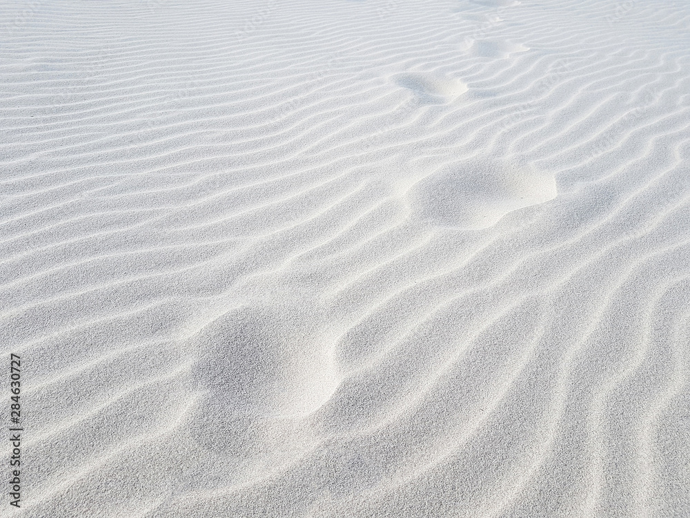 Footprints on sand dune. White sand closeup Footprints on sand dune. White sand closeup