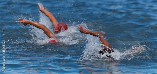 Group people in wetsuit swimming at triathlon