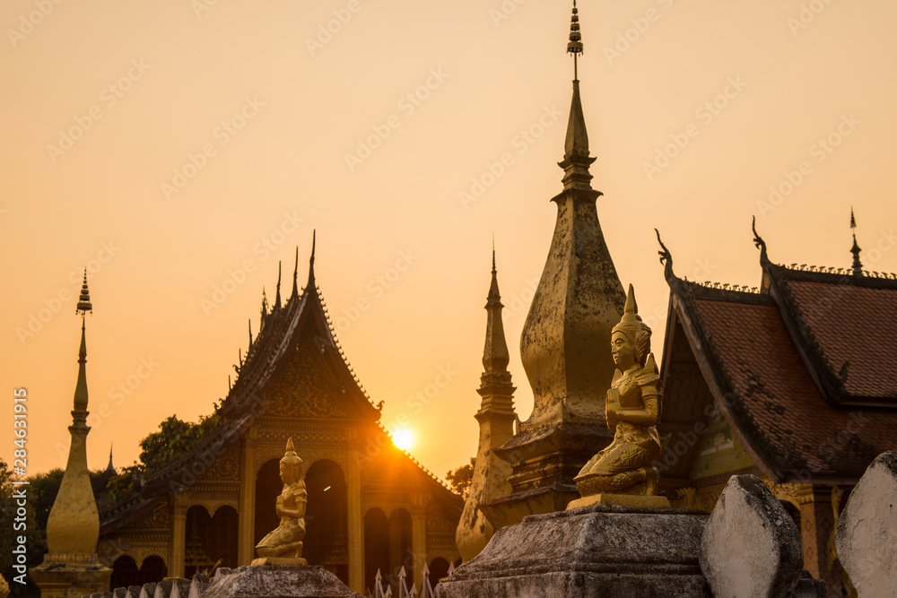 Fototapeta premium Beautiful sunset with old temple in Luang Prabang the UNESCO world heritage town in north central of Laos. 