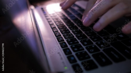 Working on Computer Laptop at Night in Office. Cropped Image of Woman's Hand Typing Keyboard. Dolly Shot