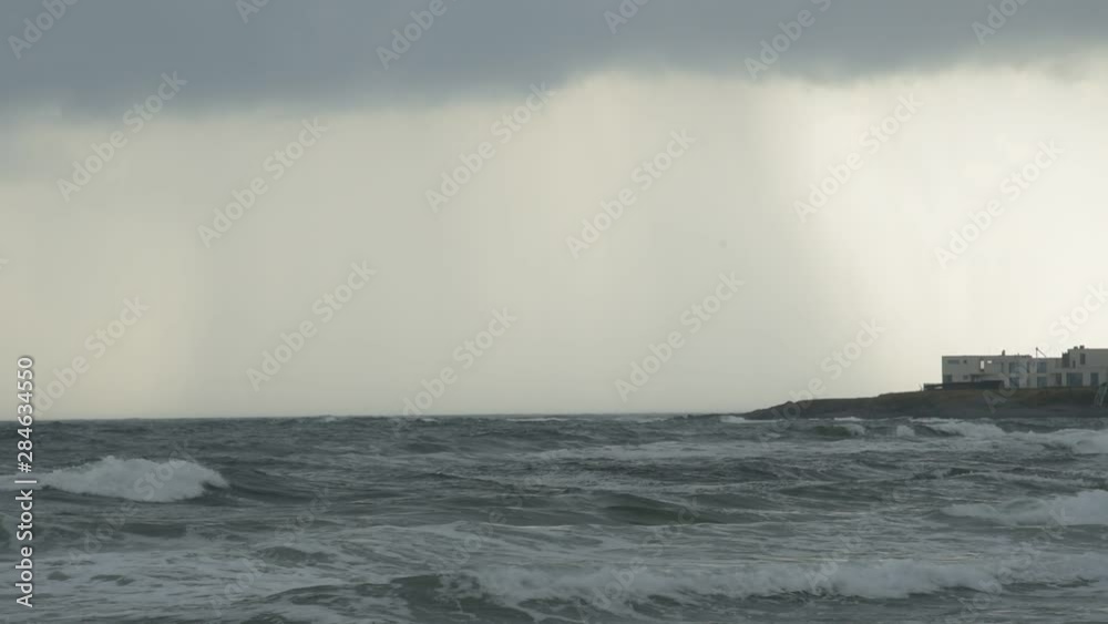 Storm hitting a Black Sea resort - strong winds blowing, waves crushing on a sandy beach, clouds hanging lowy Storm hitting a Black Sea resort - strong winds blowing, waves crushing on a sandy beach, clouds hanging lowy