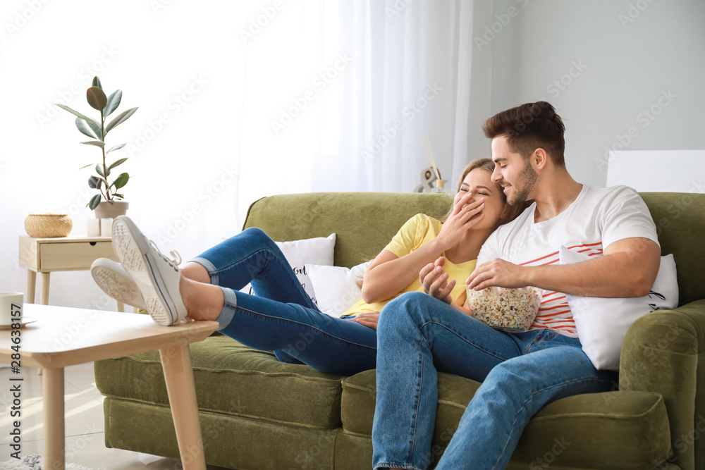 Happy couple watching TV at home Happy couple watching TV at home