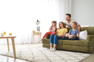 Happy family watching TV at home