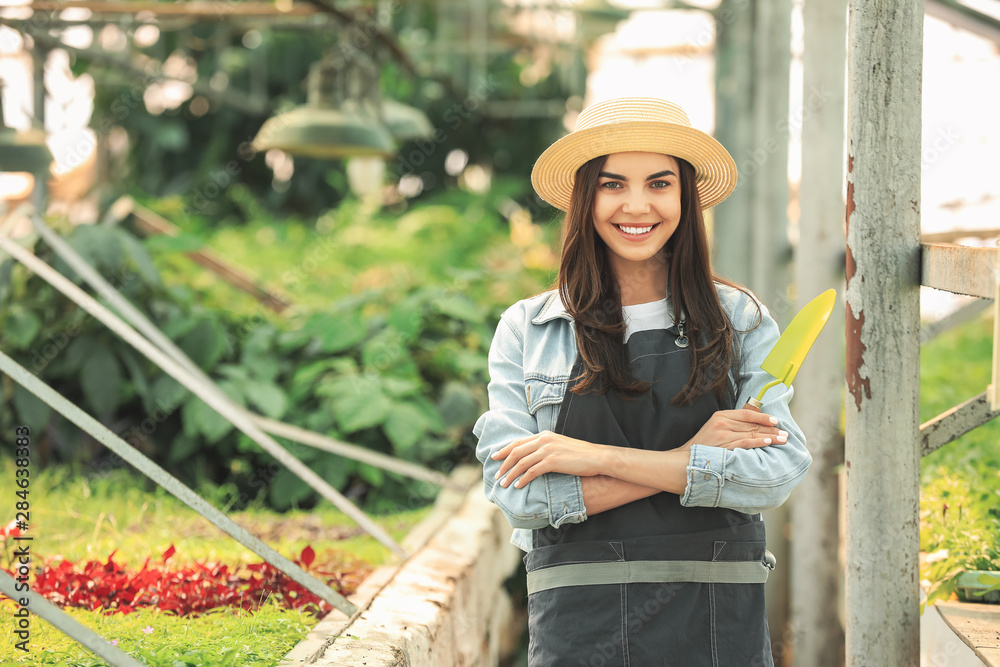 Obraz premium Beautiful female gardener in greenhouse