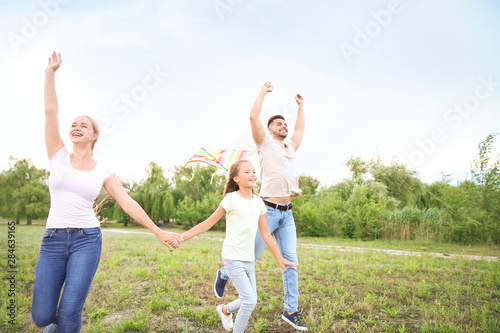 Happy family flying kite ou...
