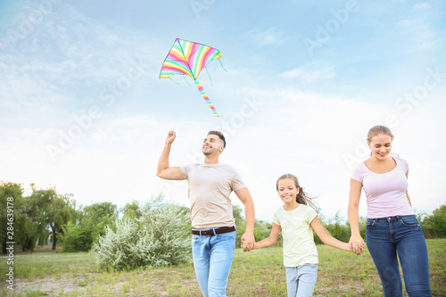 Happy family flying kite ou...