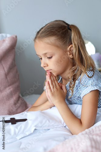 Cute little girl praying in...