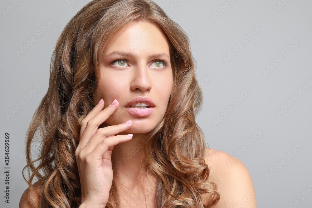 Beautiful young woman on grey background Beautiful young woman on grey background