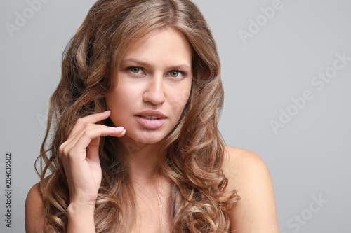 Beautiful young woman on grey background