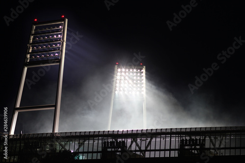 floodlight of the weser stadion at gametime at night with smoke photo