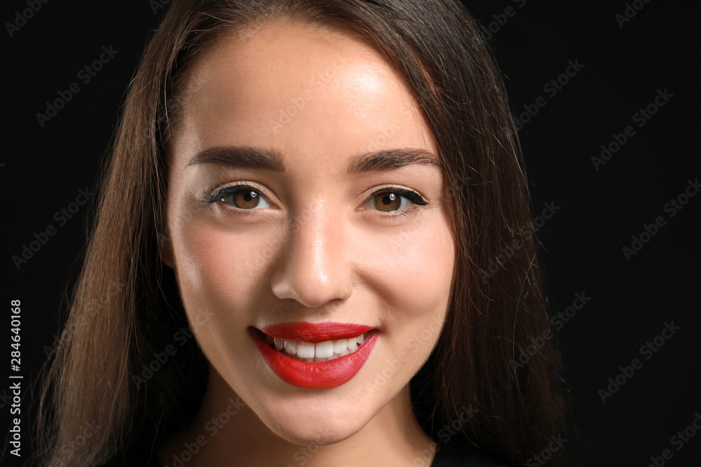 Beautiful young woman with bright lipstick on dark background Beautiful young woman with bright lipstick on dark background