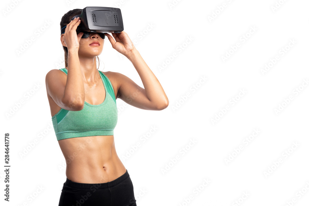 Fitness woman wearing VR headset isolated in white background. Asian girl, focus mood.