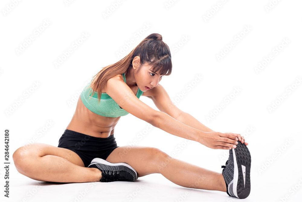 Obraz premium Fitness woman stretching isolated in white background. Asian girl in full body shot. Leg stretch sitting on floor.