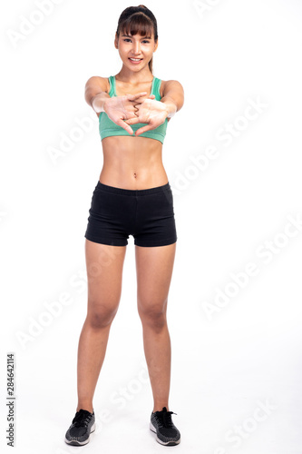 Fitness woman stretching isolated in white background. Asian girl in full body shot. Both arms sstretch with a smile.