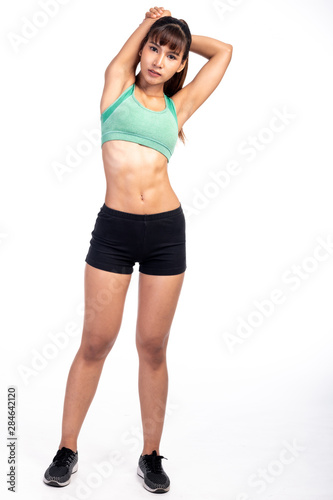 Fitness woman stretching isolated in white background. Asian girl in full body shot. Right shoulder stretch. © Baan Taksin Studio