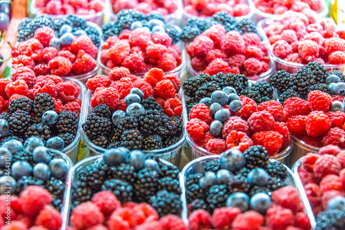 Raspberries, blueberries and blackbarries on the street market photo