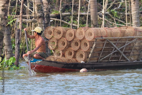 Fischer mit Reusen auf Holzboot am Rudern photo