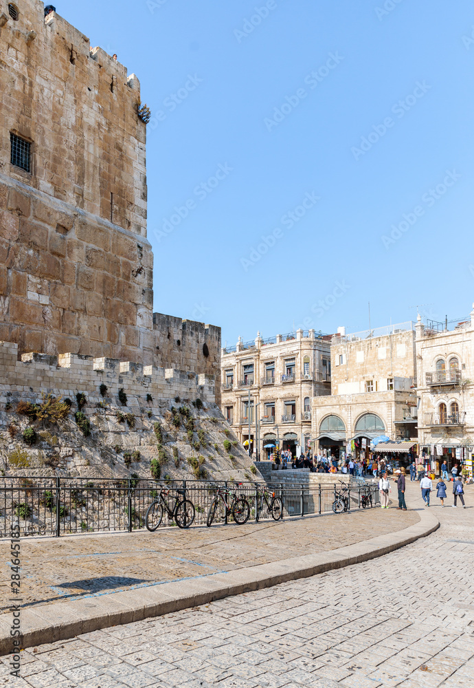 The corner of the fortress wall surrounding Tower of David and crowded Omar Ben el-Hatab street near Jaffa Gate in the old city of Jerusalem, Israel