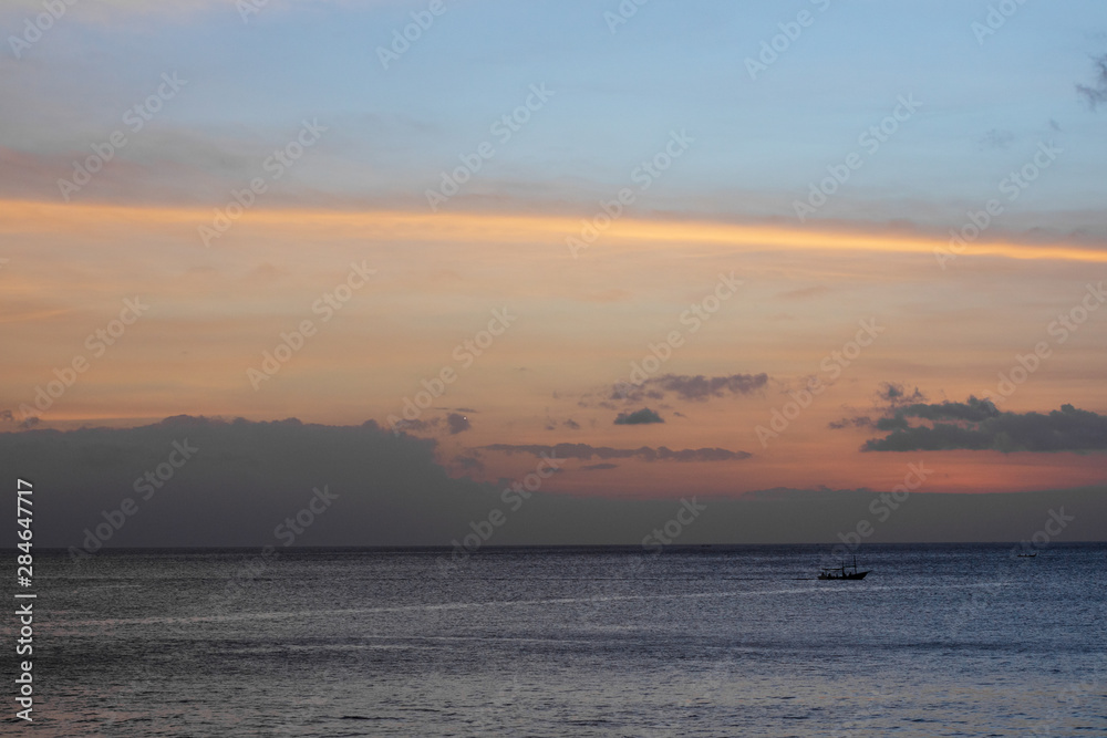 A traditional small fishing boat sailing in the ocean A traditional small fishing boat sailing in the ocean