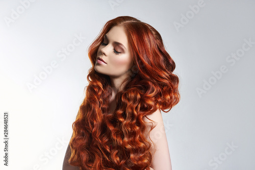 Creative bright coloring of a woman's hair, careful care of the hair roots. Bright dye for coloring, long strong hair. Natural cosmetics, natural beauty. Girl with red, redhead, purple hair