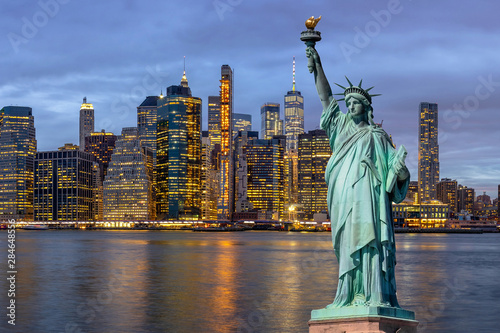 The Statue of Liberty over the Scene of New york Cityscape with Brooklyn Bridge beside the east river at the twilight time,Architecture and building with tourist concept, United state of America, USA
