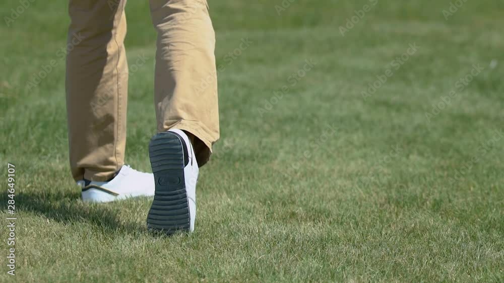 Male golf player making shot with iron club, practicing in country golf club Male golf player making shot with iron club, practicing in country golf club
