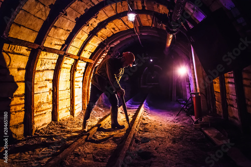 Miner working a jackhammer in a coal mine. Work in a coal mine. Portrait of a miner. Copy space. photo