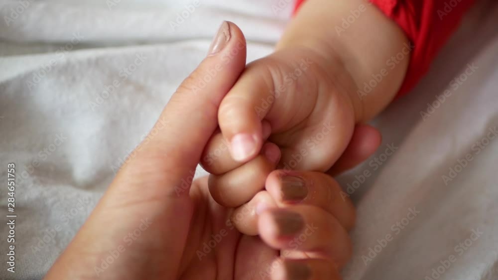 Hand of a newborn. Mother holding a baby hand. Newborn baby hand in mother's arms. close-up Hand of a newborn. Mother holding a baby hand. Newborn baby hand in mother's arms. close-up