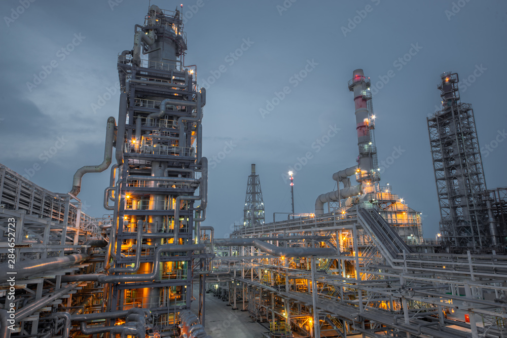 view of metal pipes of illuminated industrial plant outdoor at night 