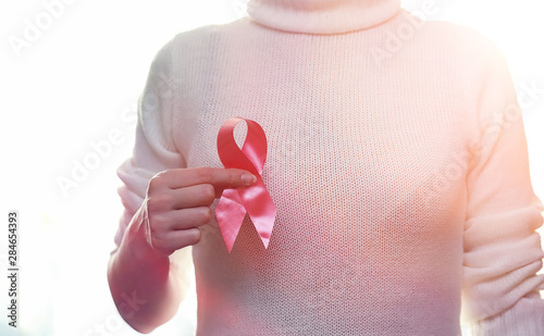 Wallpaper Mural The red ribbon of the girl. The girl is holding a red ribbon. Health concept and red ribbon. Breast cancer. Torontodigital.ca
