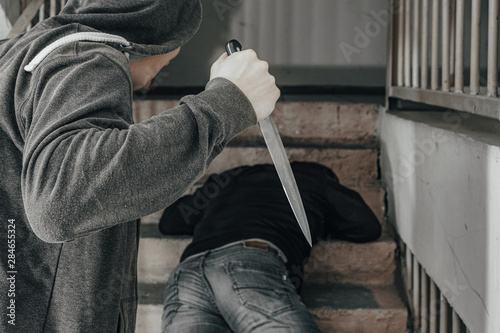 A man with a knife is trying to kill a man on the landing. topics of violence and murder. thief, killer, rapist, maniac, robbery